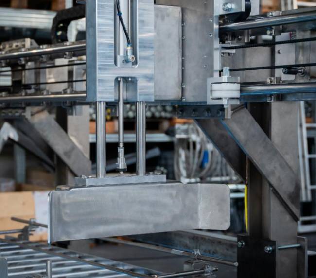 Spintore elettrico progettato da Movin per trasferire cassette movimentate su diversi trasportatori a rulli motorizzati in zona ATEX