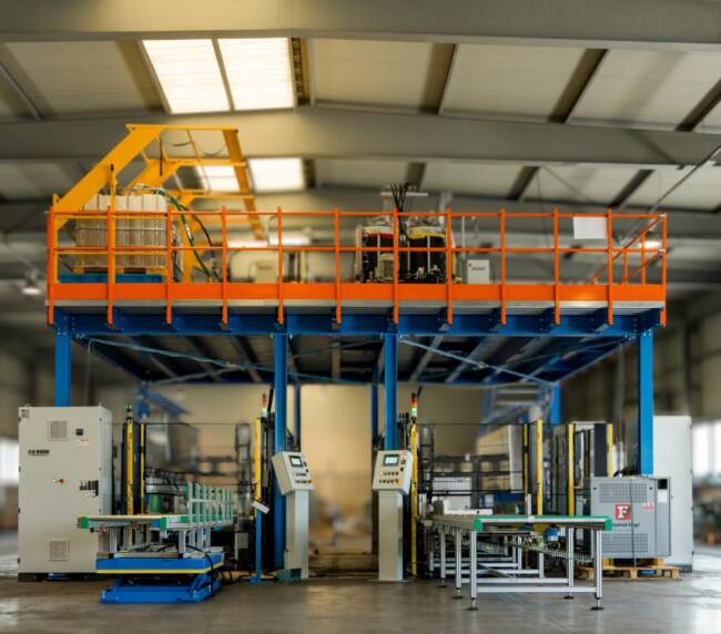 Area di preparazione dei pannelli schiumati progettata da Movin con soppalco, system di iniezione poliuretano e maschere di schiumatura a monte della line di assembly di banchi frigo commerciali