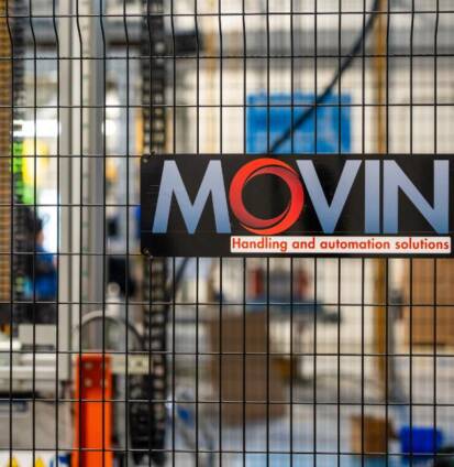 Logo Movin applicato su reti fisiche di sicurezza certificate per garantire la sicurezza degli operatori di linea durante le attività automatizzate dell’impianto produttivo