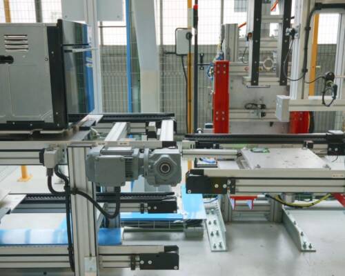 Stazione di cambio pallet per passare dal pallet utilizzato per l’assemblaggio al pallet per i test elettrici, con relativo ritorno pallet automatizzato, all’interno della linea di assemblaggio elettrodomestici realizzata da Movin